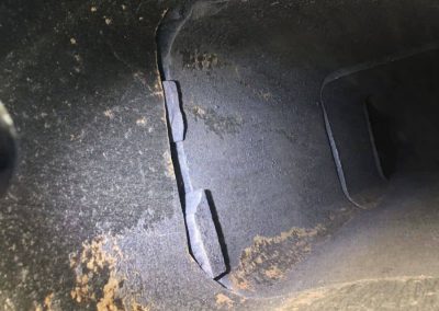 Close-up of a cracked, weathered interior surface with jagged edges and uneven lighting.