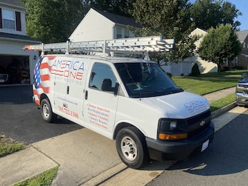 White service van parked in driveway with ladders on top, displaying patriotic branding and contact info for expert chimney sweeps.