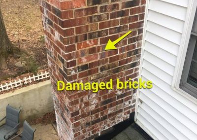 Brick chimney with visible damage and missing bricks, highlighted by arrows and labeled "Damaged bricks.