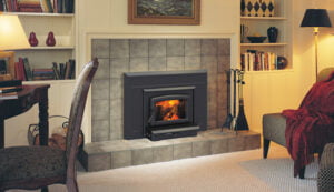 Cozy living room with a lit fireplace, bookshelves creating a warm Knowledge Center, and a red blanket draped over a sofa.