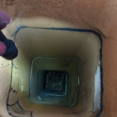 Looking down a chimney flue at cracked tile joints