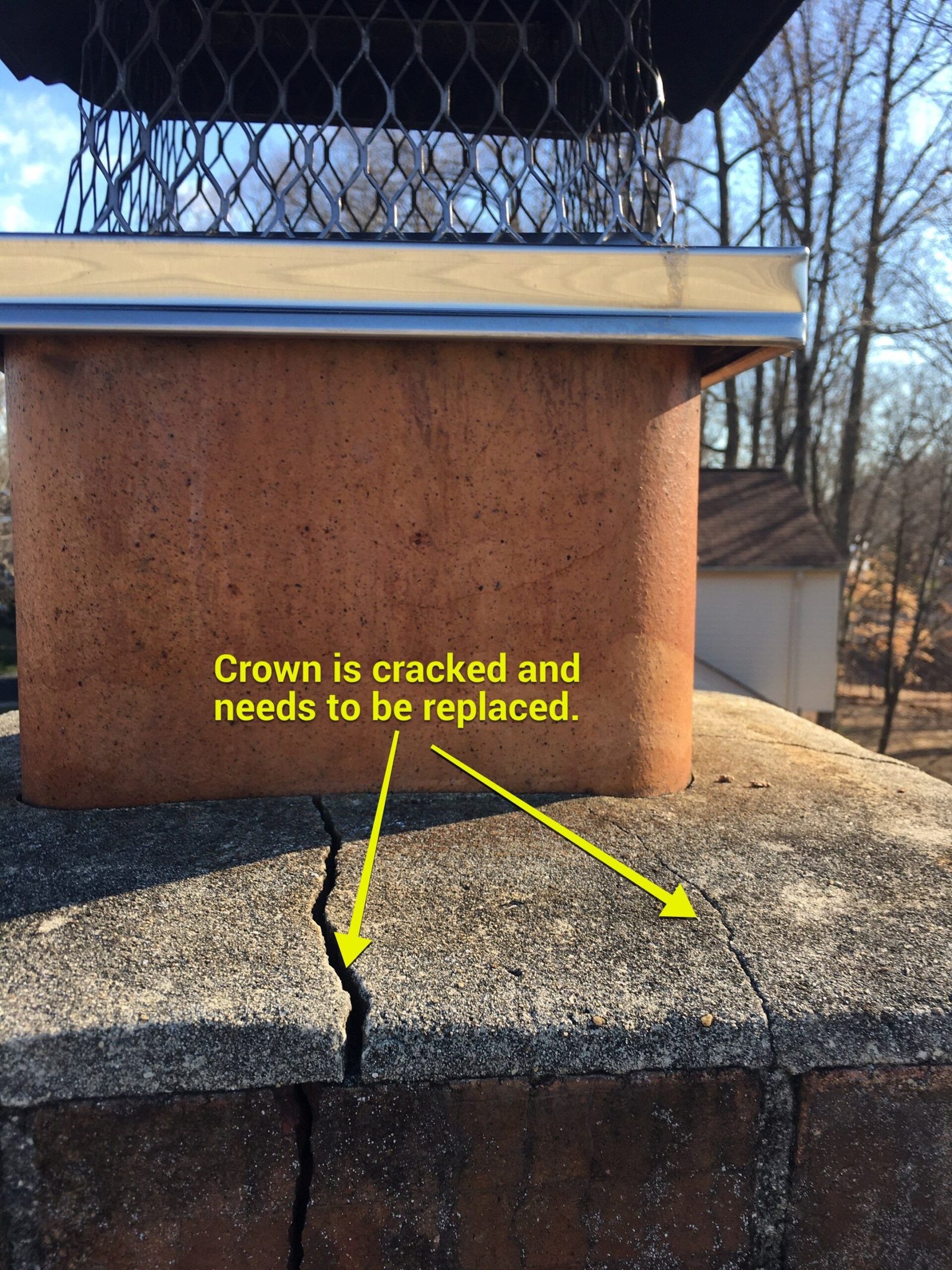 Annotated inspection photo of a cracked chimney crown needing replacement