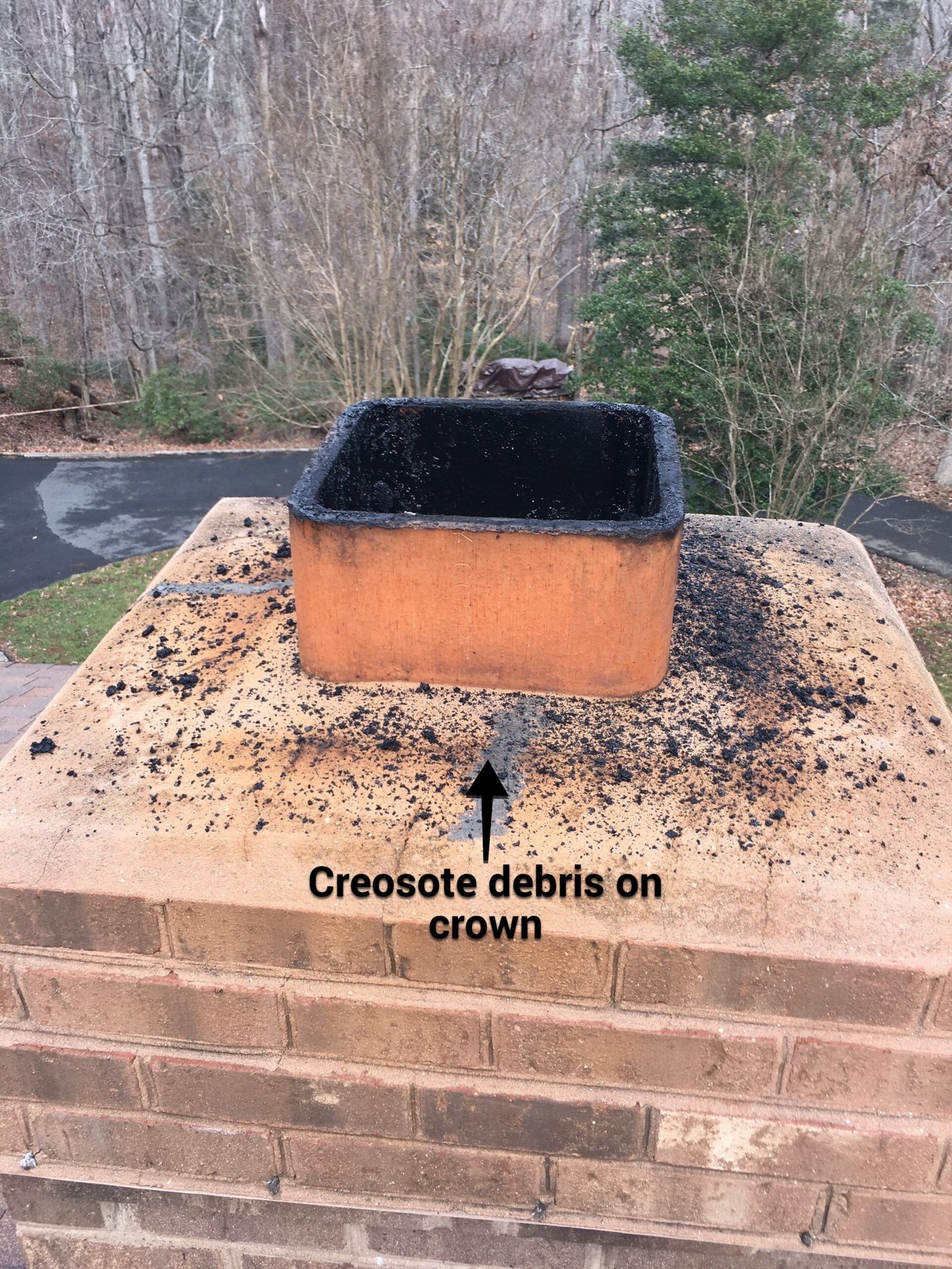 Burned creosote debris scattered on a chimney crown after a quiet chimney fire
