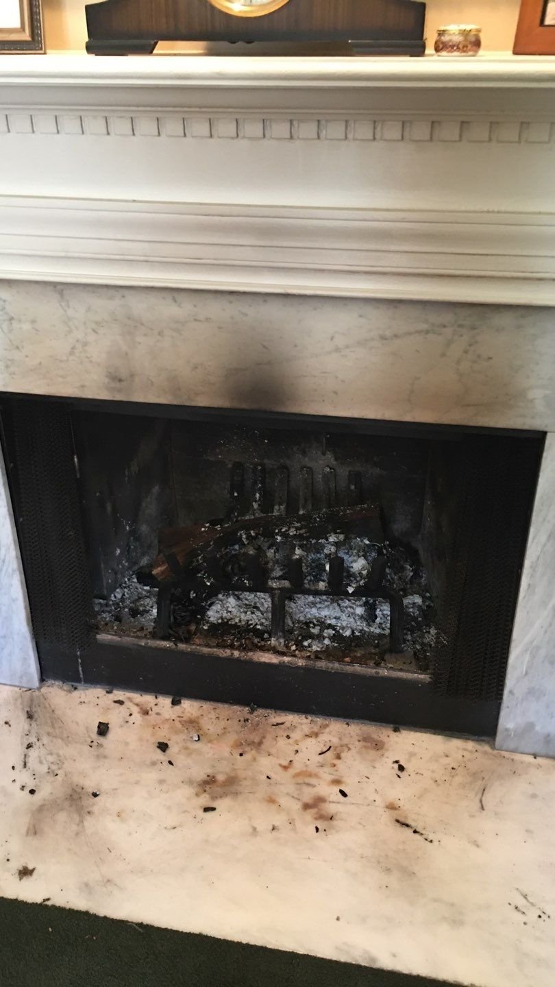 Soot staining above a fireplace opening from smoke entering the room